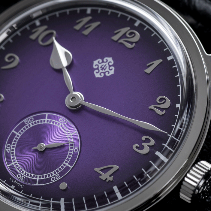 Close-up of a watch with a purple face and silver accents